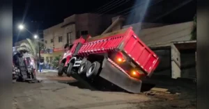 Caminhão tombado durante operação de remoção em Arapongas após afundamento do asfalto e espalhamento de massa asfáltica na via.