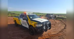 Caminhão tomba na PR-317 em Iguaraçu e deixa passageiro ferido. Imagem mostra viatura da Polícia Militar sinalizando o trecho da rodovia ao lado do veículo tombado.